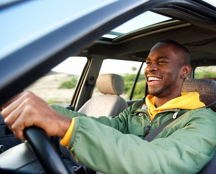 Man smiles while driving off
