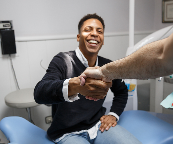Dental patient shaking dentists hand