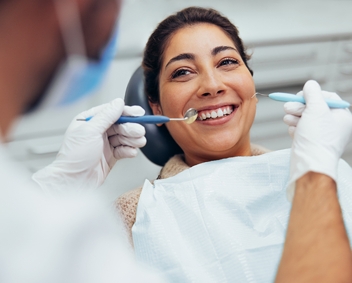 Woman sitting in dental chair and smiling