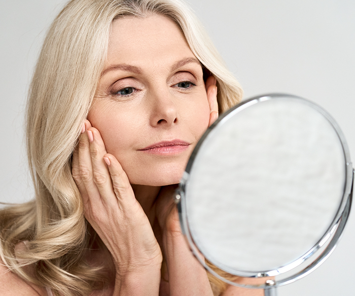 Woman with jaw pain looking in small mirror