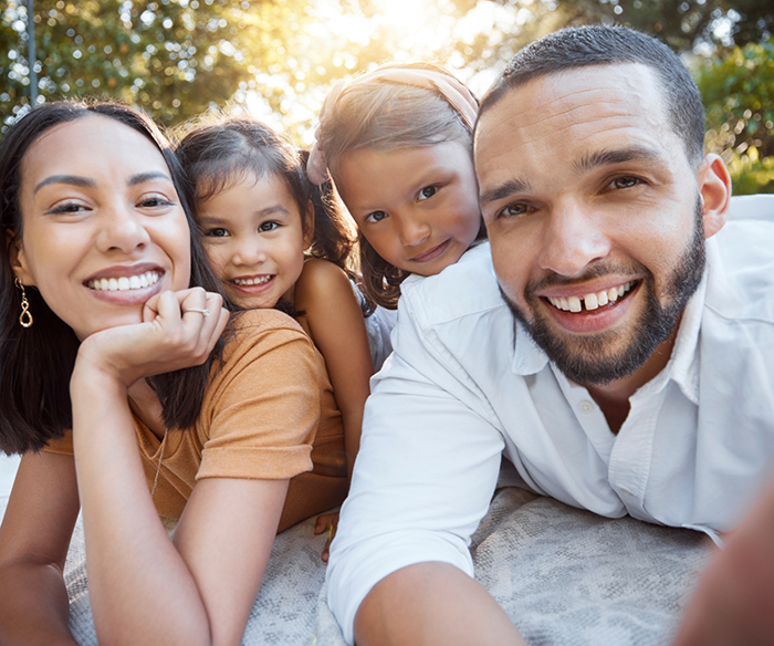Man and woman leaning forward with children on their backs