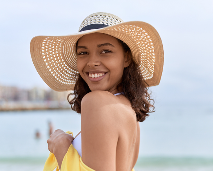 Woman in straw hat looking back and smiling