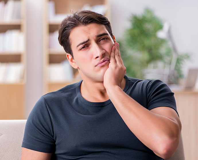 Man sitting on couch with tooth pain