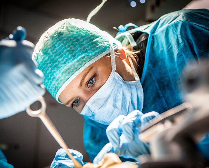 Close up of dentist with mask treating patient