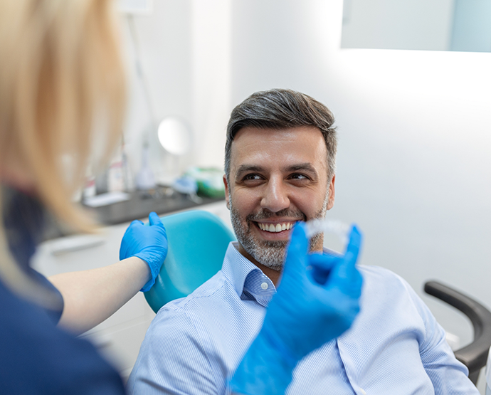 Man sitting in dental chair and smiling