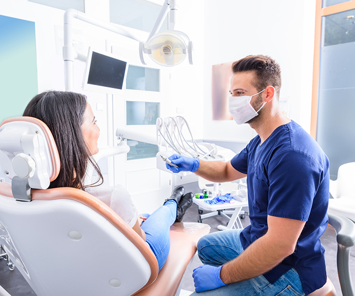 Dentist sitting and speaking to dental patient