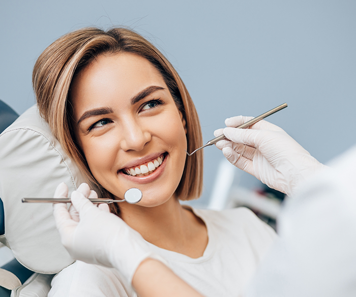 Woman sitting in dental chair and smiling