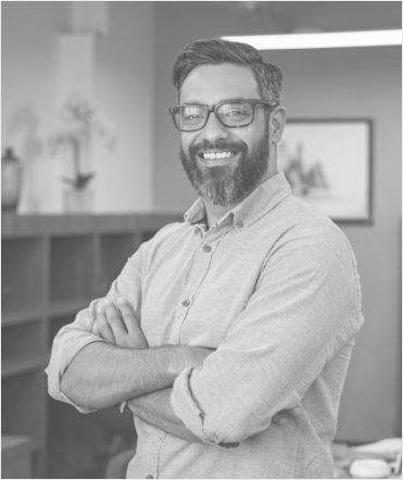 Man with glasses smiling with arms folded