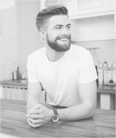 Man with beard leaning on counter and smiling
