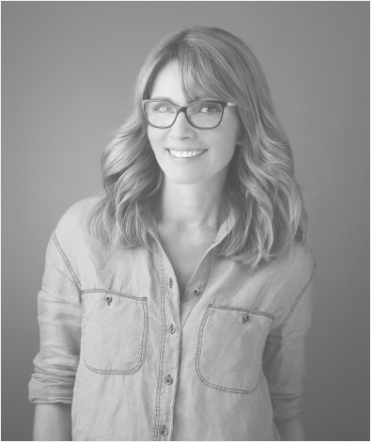 Woman with glasses standing and smiling