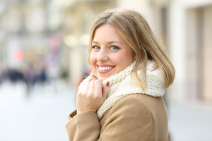 Close-up of woman in winter clothes smiling
