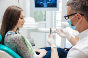 Dentist showing patient a dental implant 